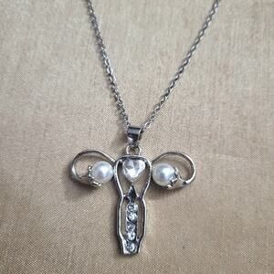Uterus shaped silver tone necklace with faux pearl ovaries & crystal heart
